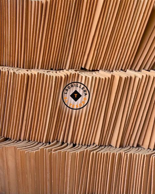Cajas de cartón marrón apiladas con un pequeño logotipo circular en la caja central.