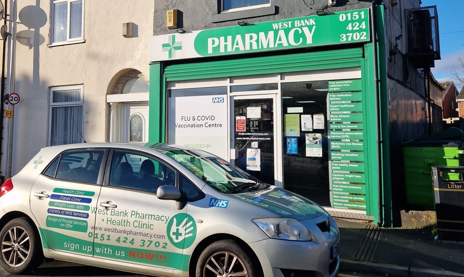 A car is parked in front of west bank travel clinic.