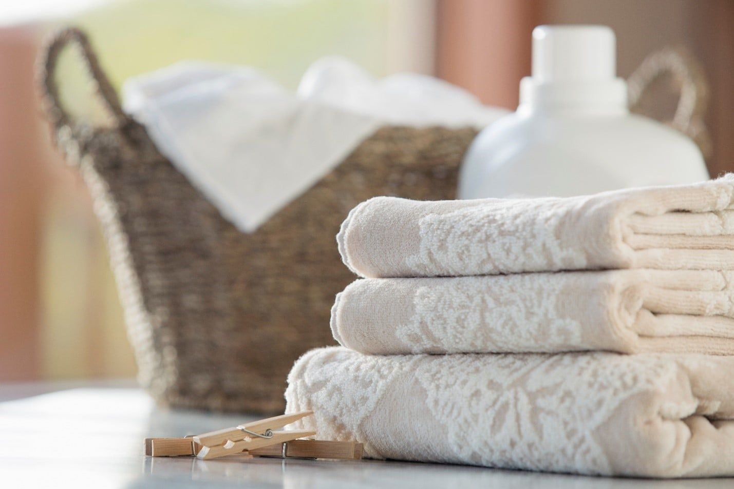 Stack of Towels is Sitting on a Table Next to a Laundry Basket — Care FNQ Pty Ltd in Cairns City, QLD