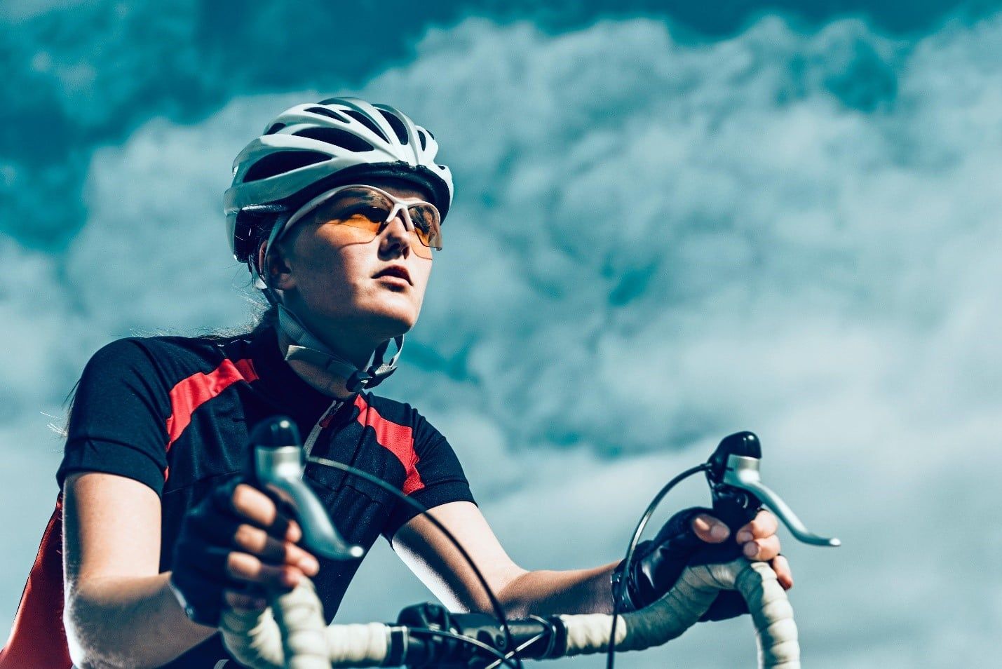 Woman Wearing a Helmet and Sunglasses is Riding a Bike — Care FNQ Pty Ltd in Cairns City, QLD