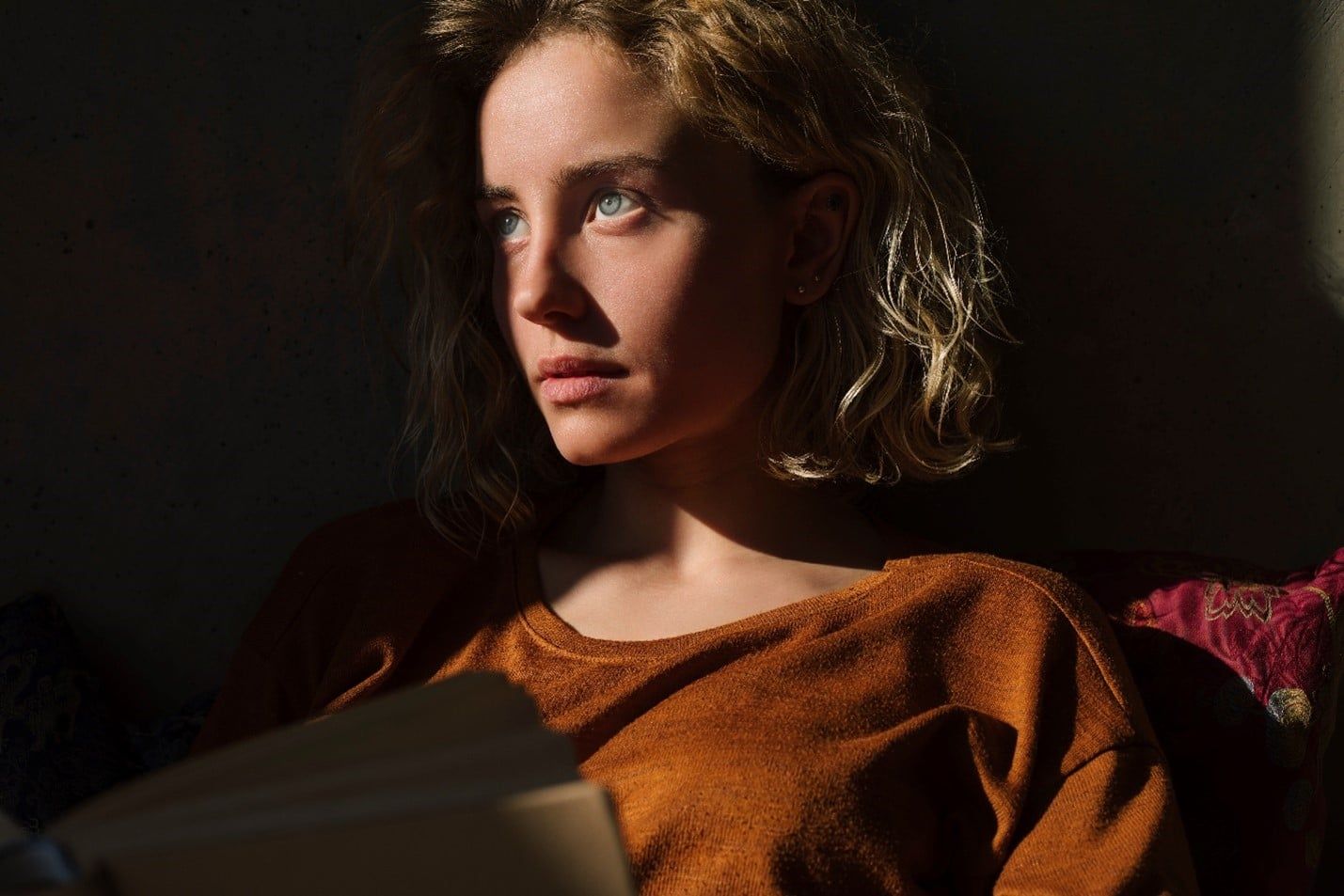 Woman is Sitting on a Couch Reading a Book — Care FNQ Pty Ltd in Cairns City, QLD
