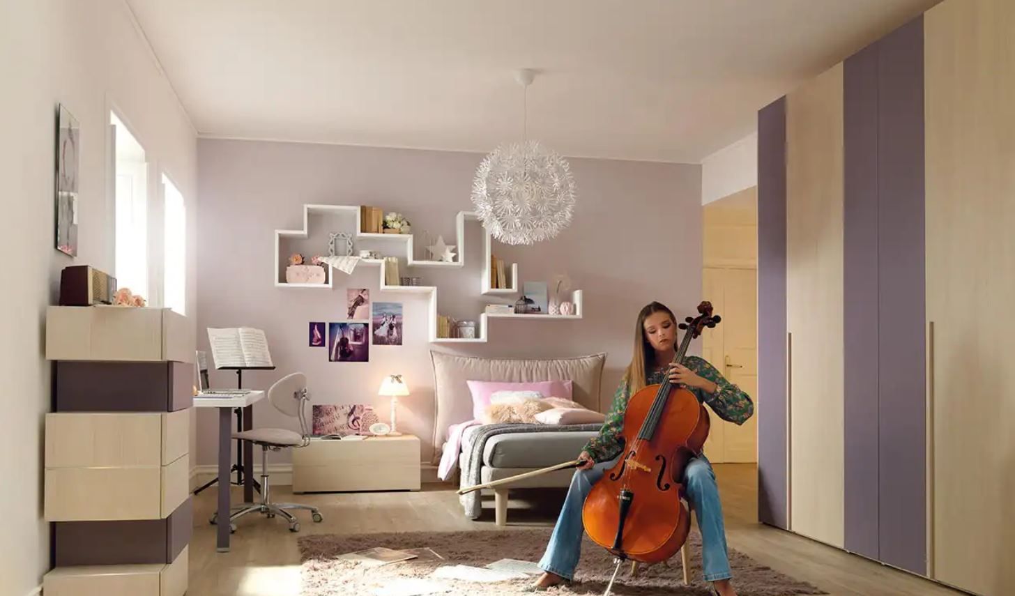 Una ragazza suona il violoncello in una camera da letto