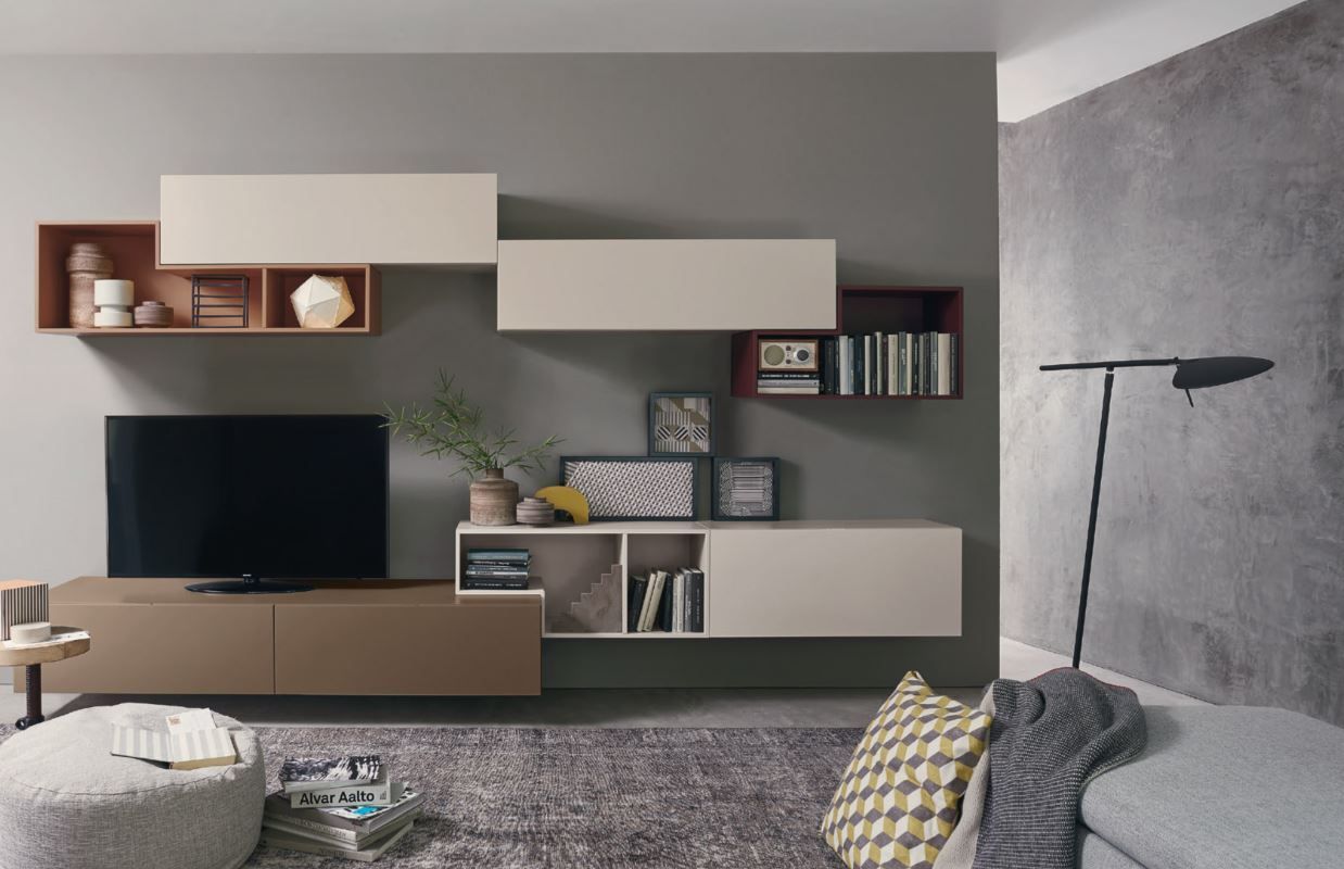 Un soggiorno con divano, televisione, scaffali e lampada.