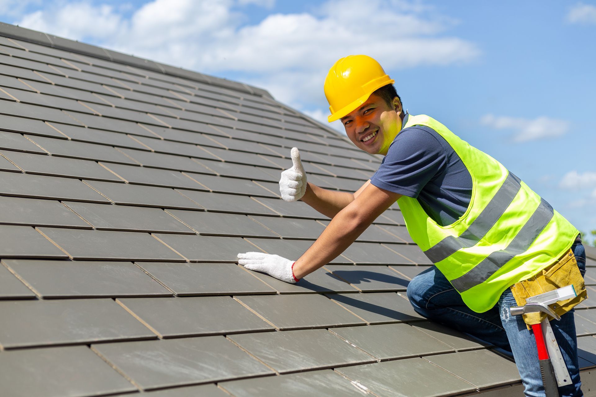 Tile roofing workers smiling at the camera, giving thumbs up to show the roof’s stability.