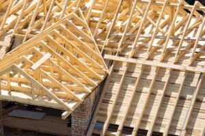 Wooden roof trusses under construction on a building.