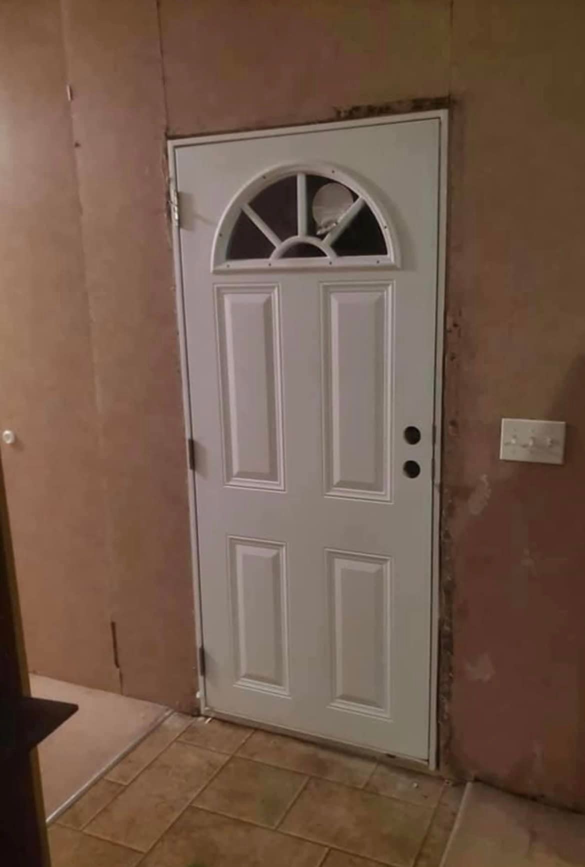 A white door with a window in a room.