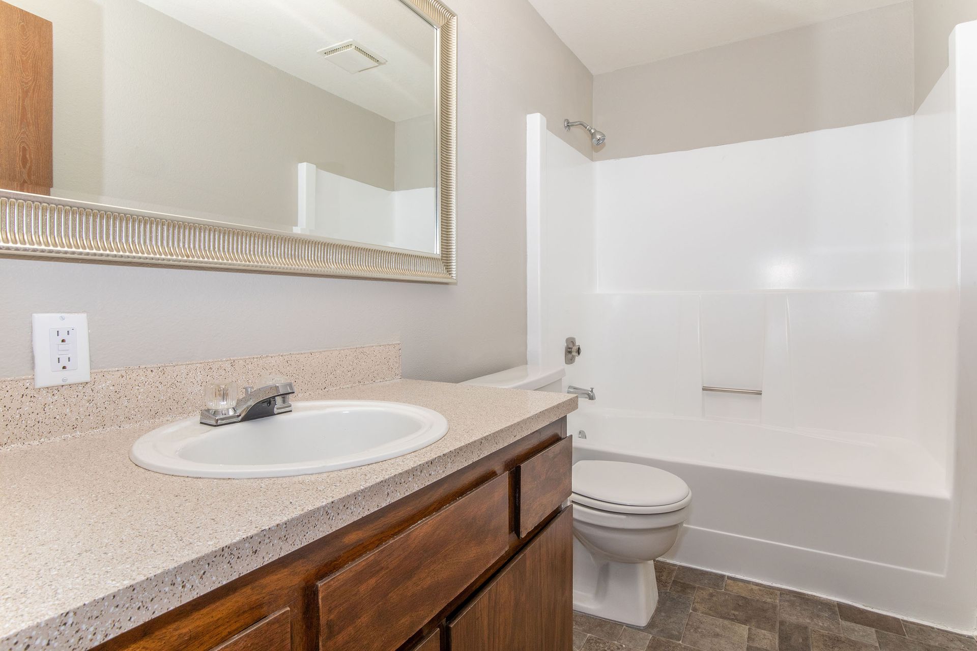A bathroom with a sink , toilet , bathtub and mirror.