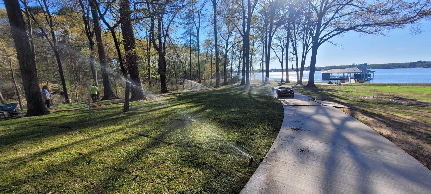 A sprinkler is spraying water on a lush green lawn.