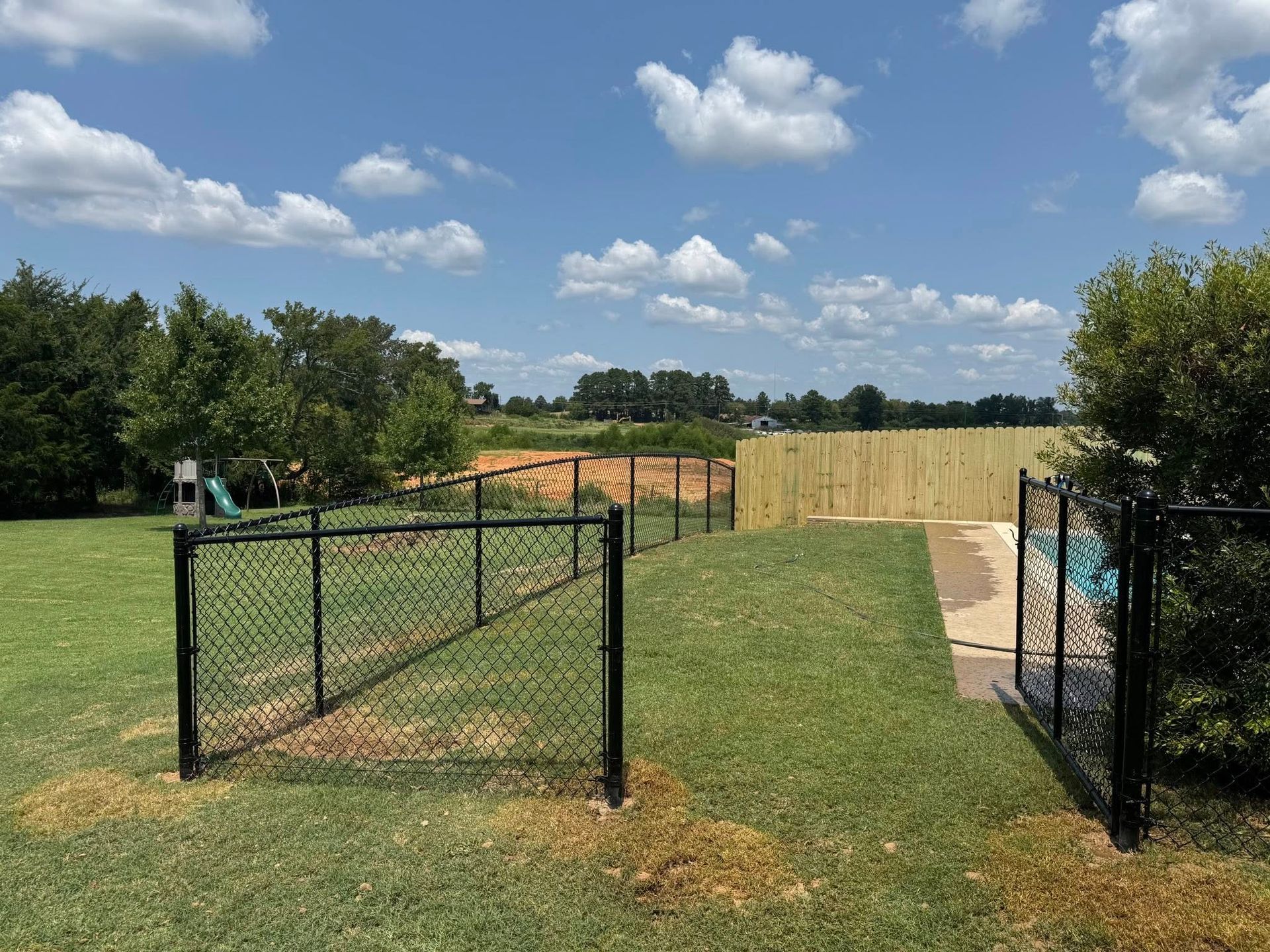 A iron fence along a path in a park.