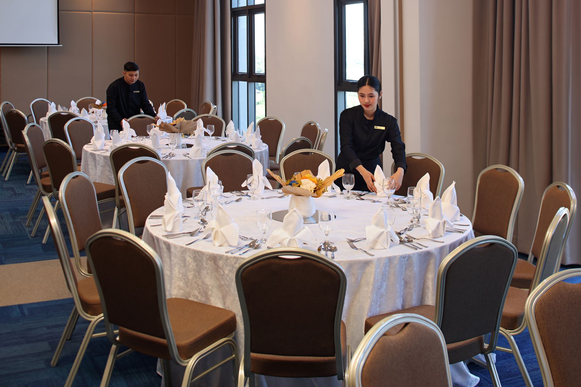 Alino Hotel staff preparing table settings for a banquet event