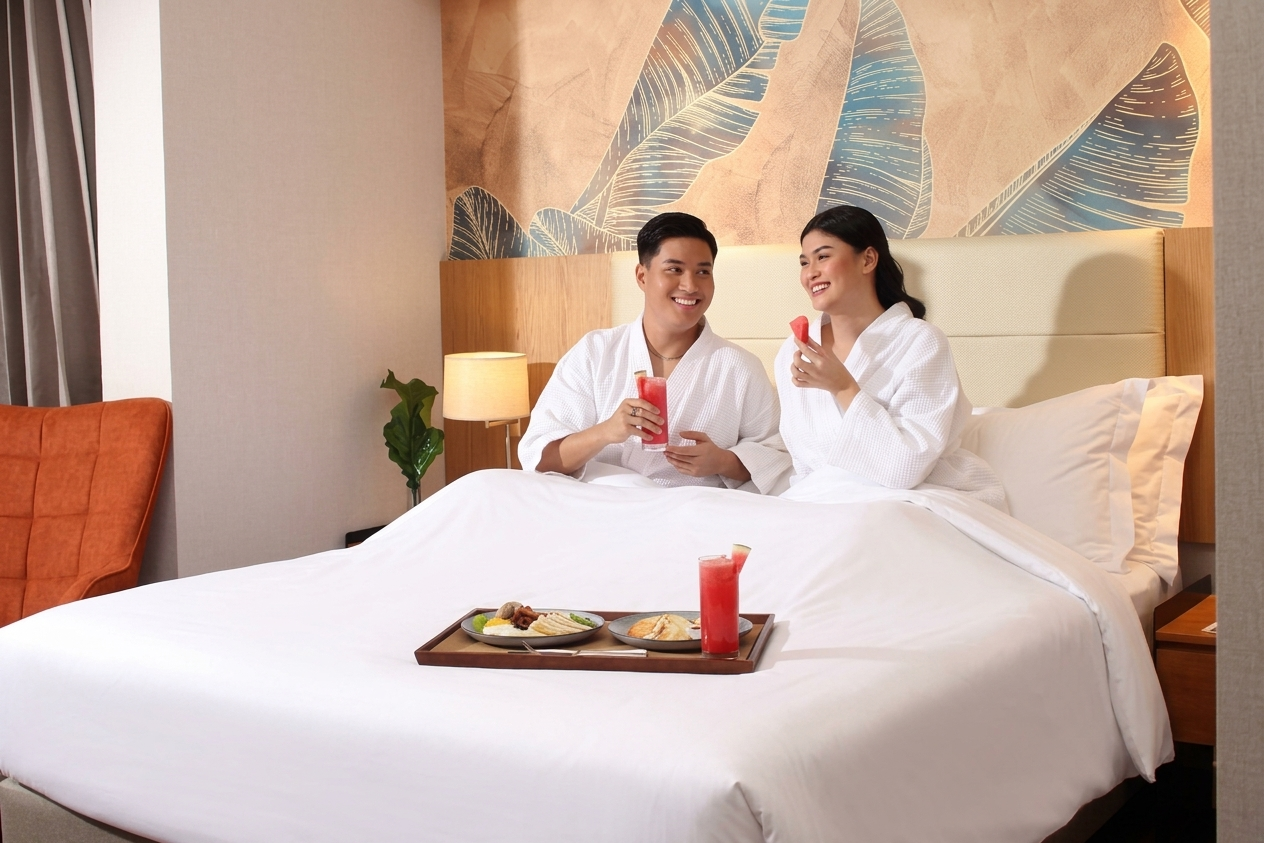 Newlyweds sharing refreshments in bed at Alino Hotel