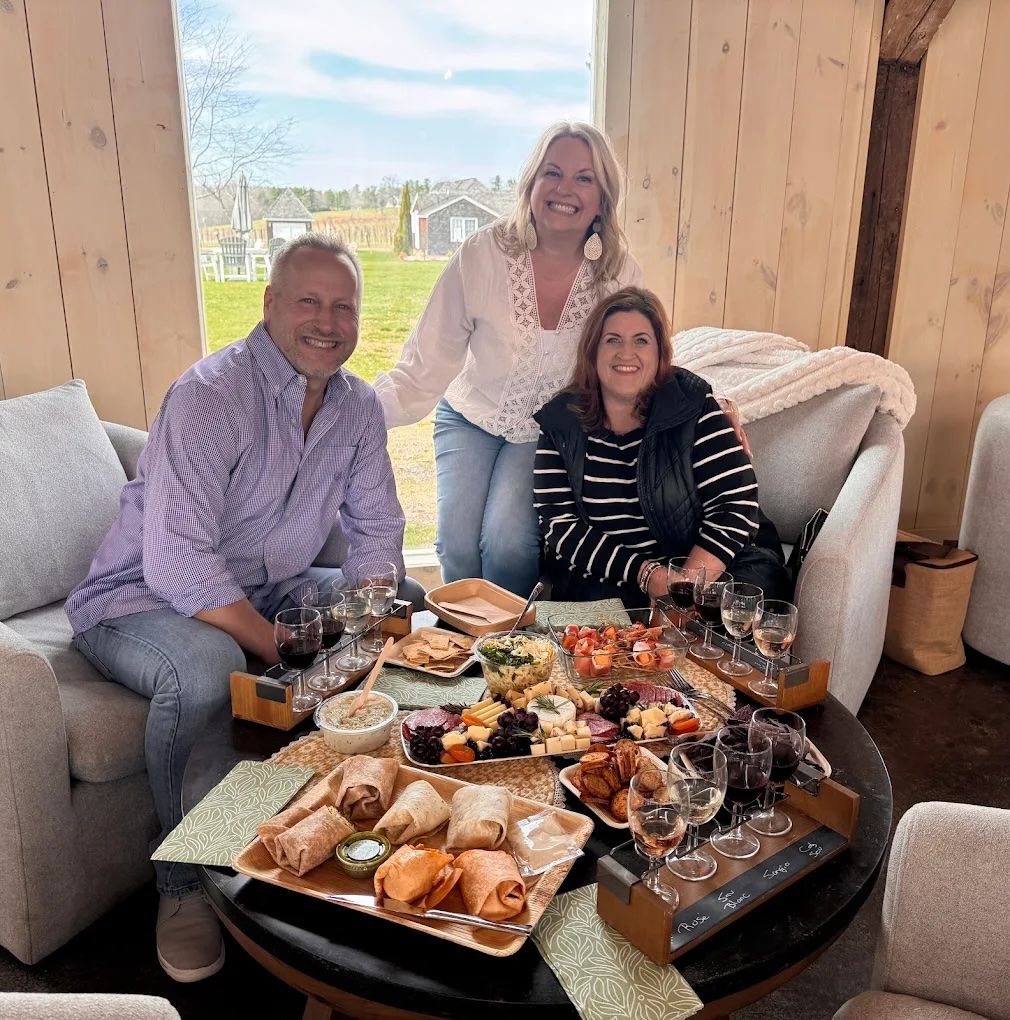 A group of people are sitting in chairs in a field with a dog