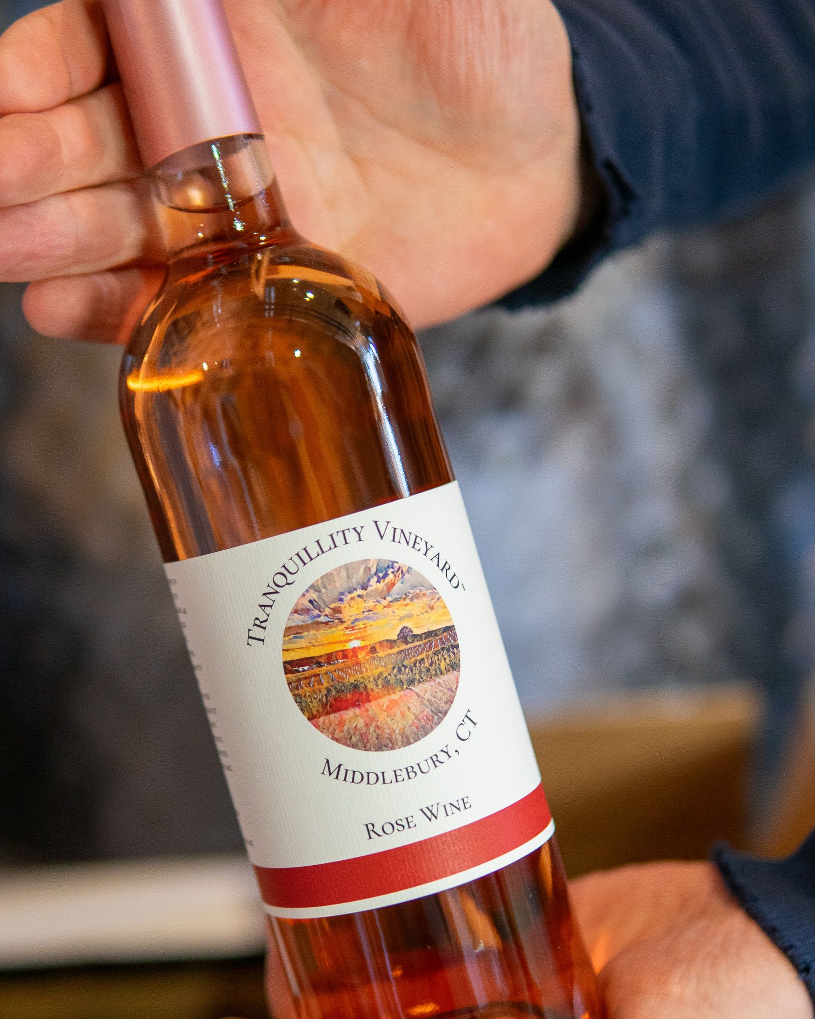 A close up of a person holding a bottle of wine