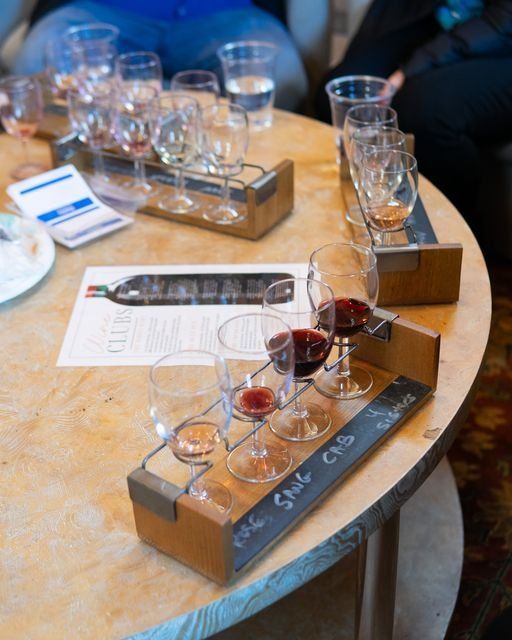 A wooden table with a tray of wine glasses on it