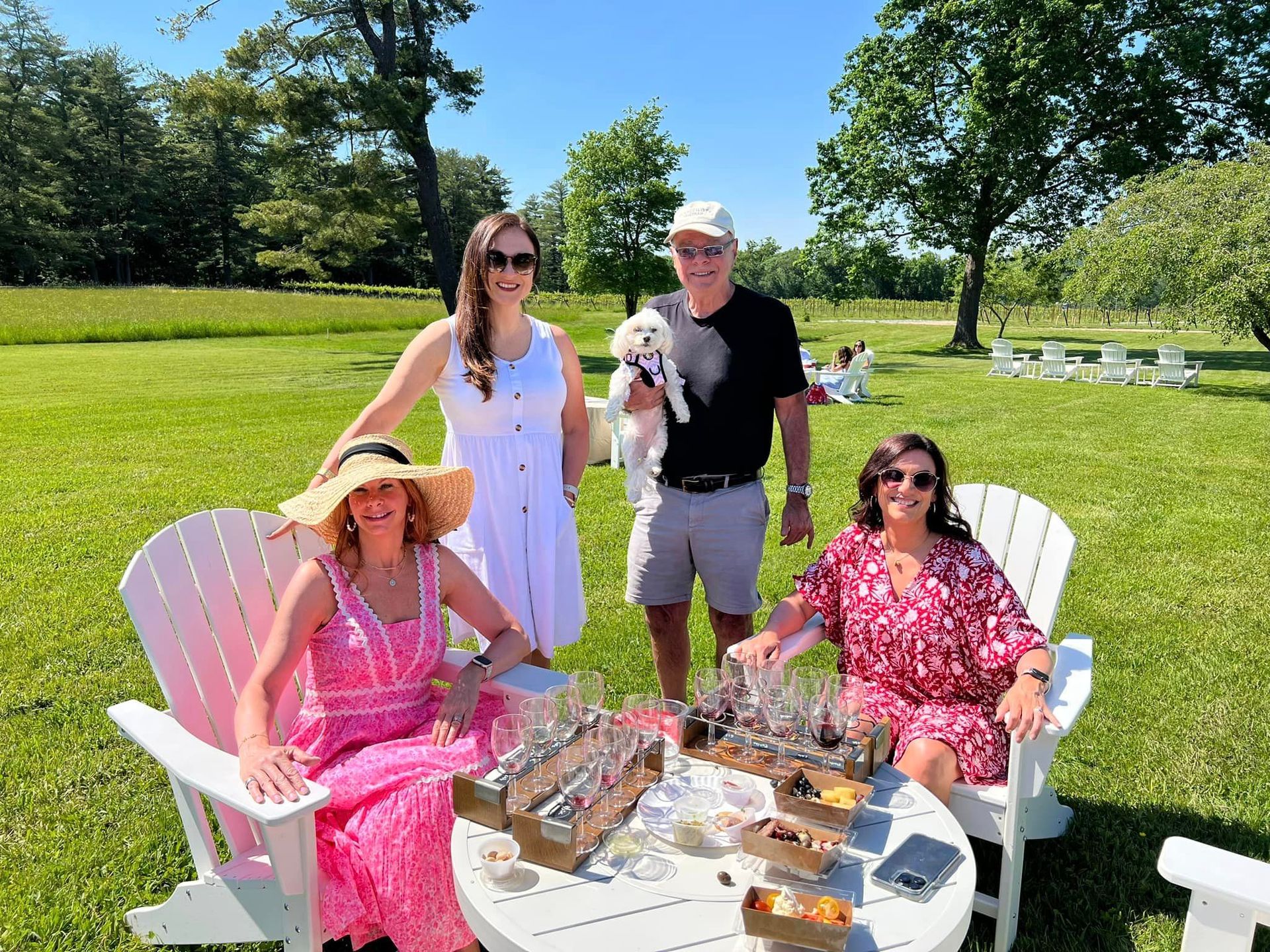 A group of people are sitting in chairs in a field with a dog