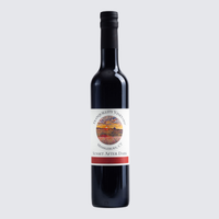 Dark glass wine bottle with a white label on a light gray background