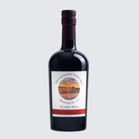Bottle of red wine with a dark label and maroon neck on a light background