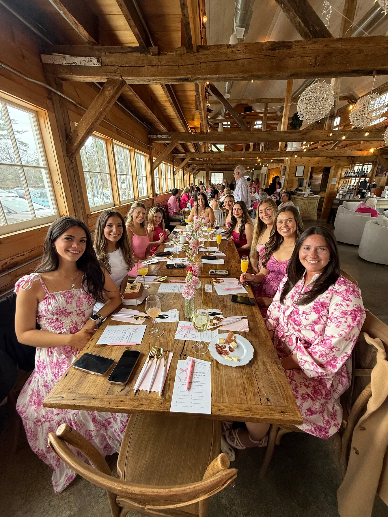 Guests seated at a long wooden dining table in a rustic lodge, smiling during a group meal