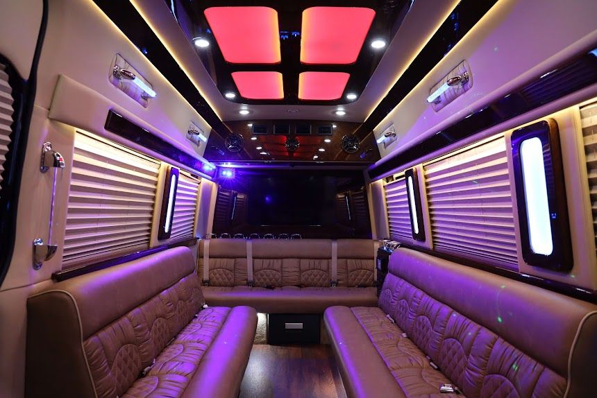 Luxury limousine interior with purple LED lighting, leather bench seating, and a ceiling skylight