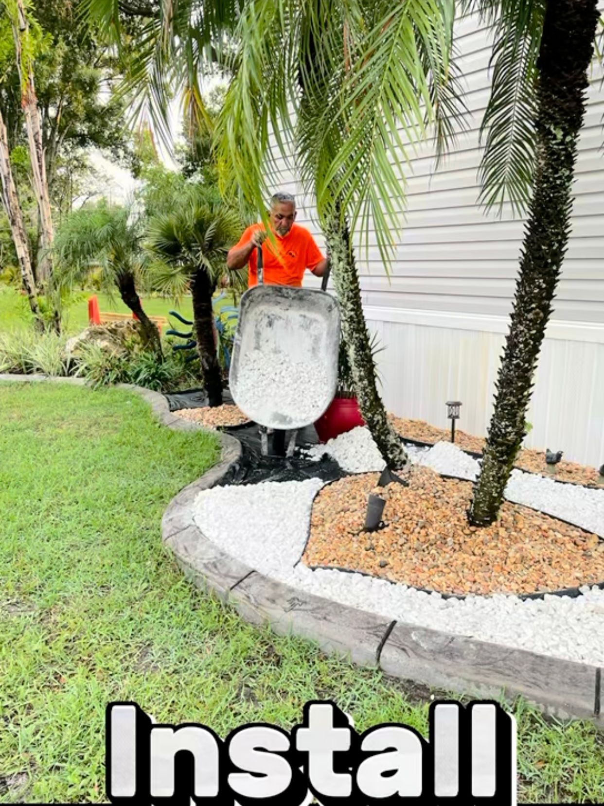 A man is pouring white gravel into a garden.