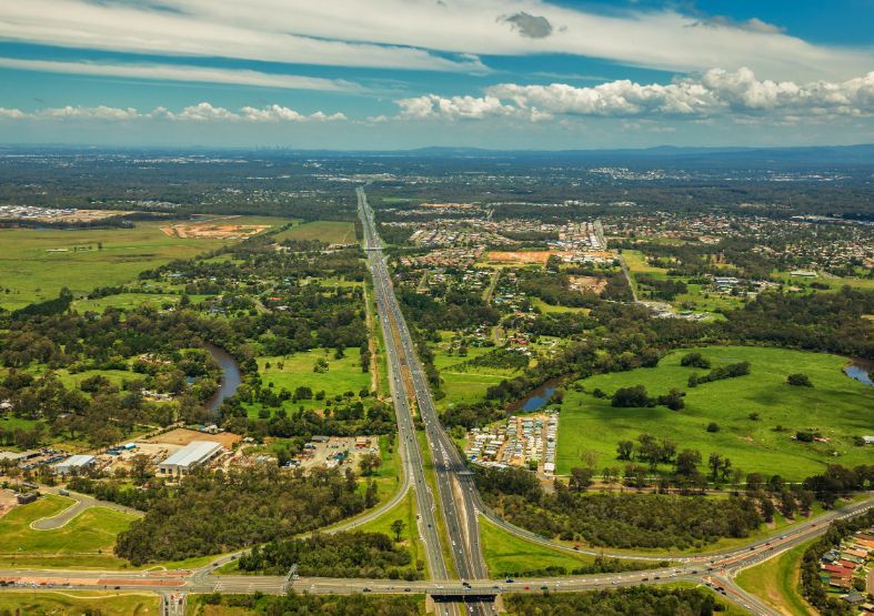 Aerial View of a Highway Cutting Through Green Fields and Forests — On Demand Diggers and Demolitions in Brisbane, QLD