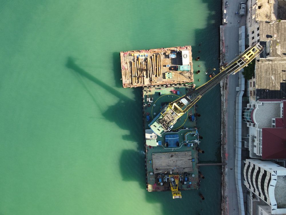 An Aerial View of a Boat in the Water With a Crane Attached to It — On Demand Diggers & Demolitions in Sunshine Coast, QLD