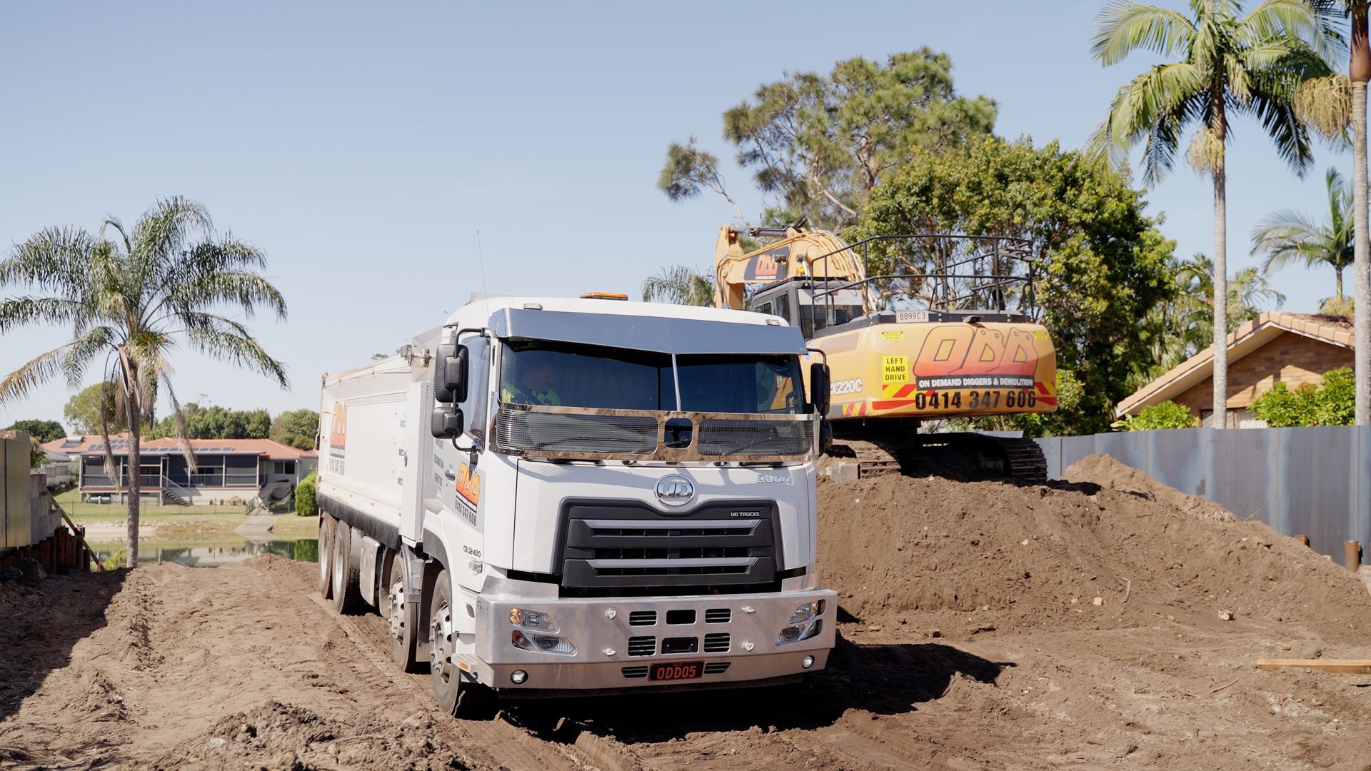 Yellow Excavator is Digging a Pile of Dirt on a Construction Site — On Demand Diggers & Demolitions in Sunshine Coast, QLD