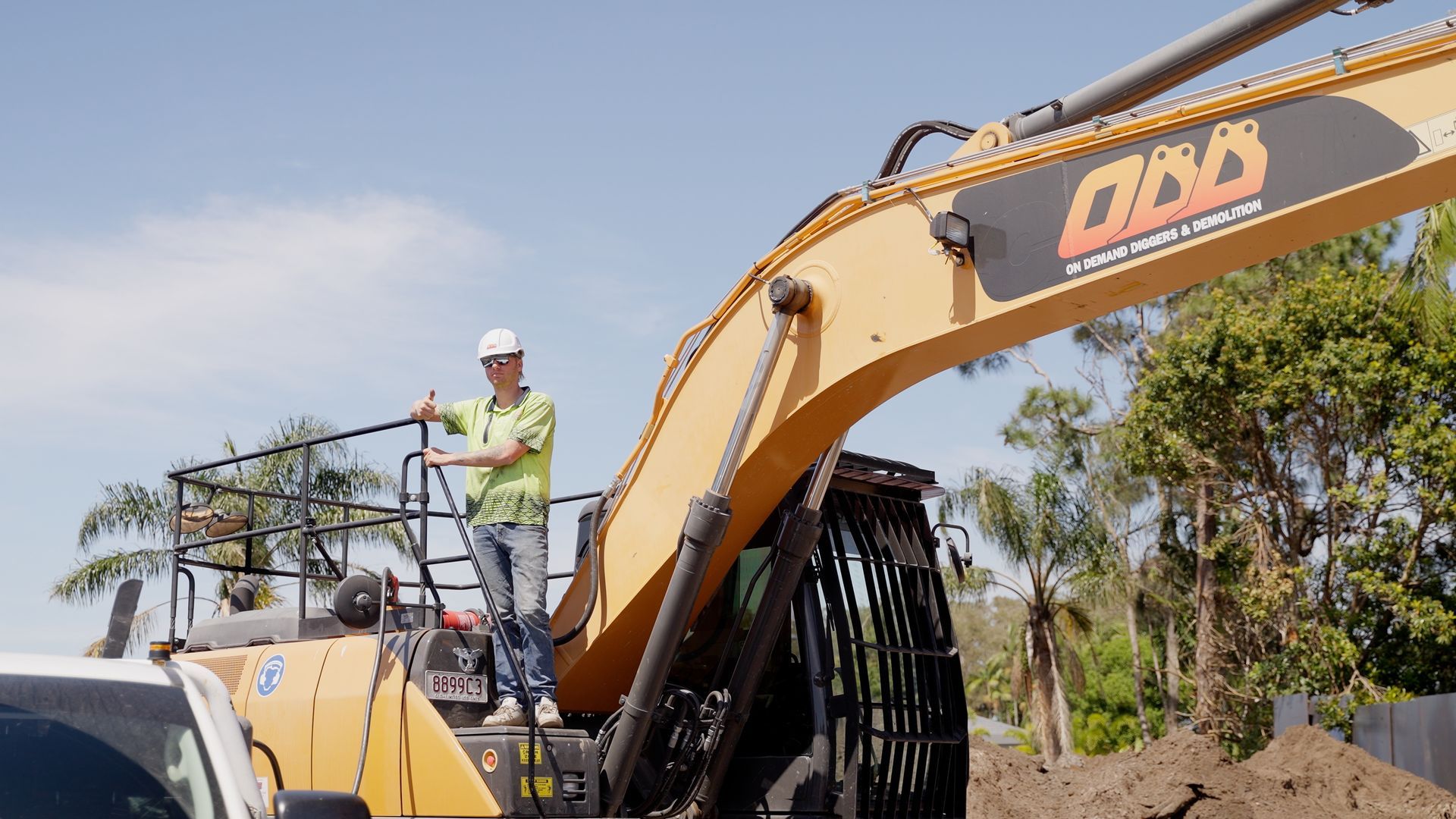 An Excavator is Loading Dirt Into a Dump Truck — On Demand Diggers & Demolitions in Sunshine Coast, QLD