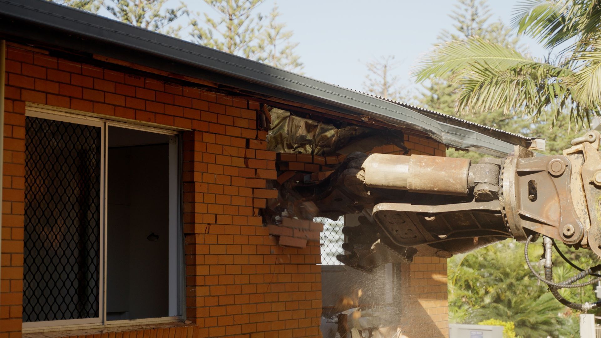 Yellow Excavator Demolishing Concrete House — On Demand Diggers & Demolitions in Molendinar, QLD