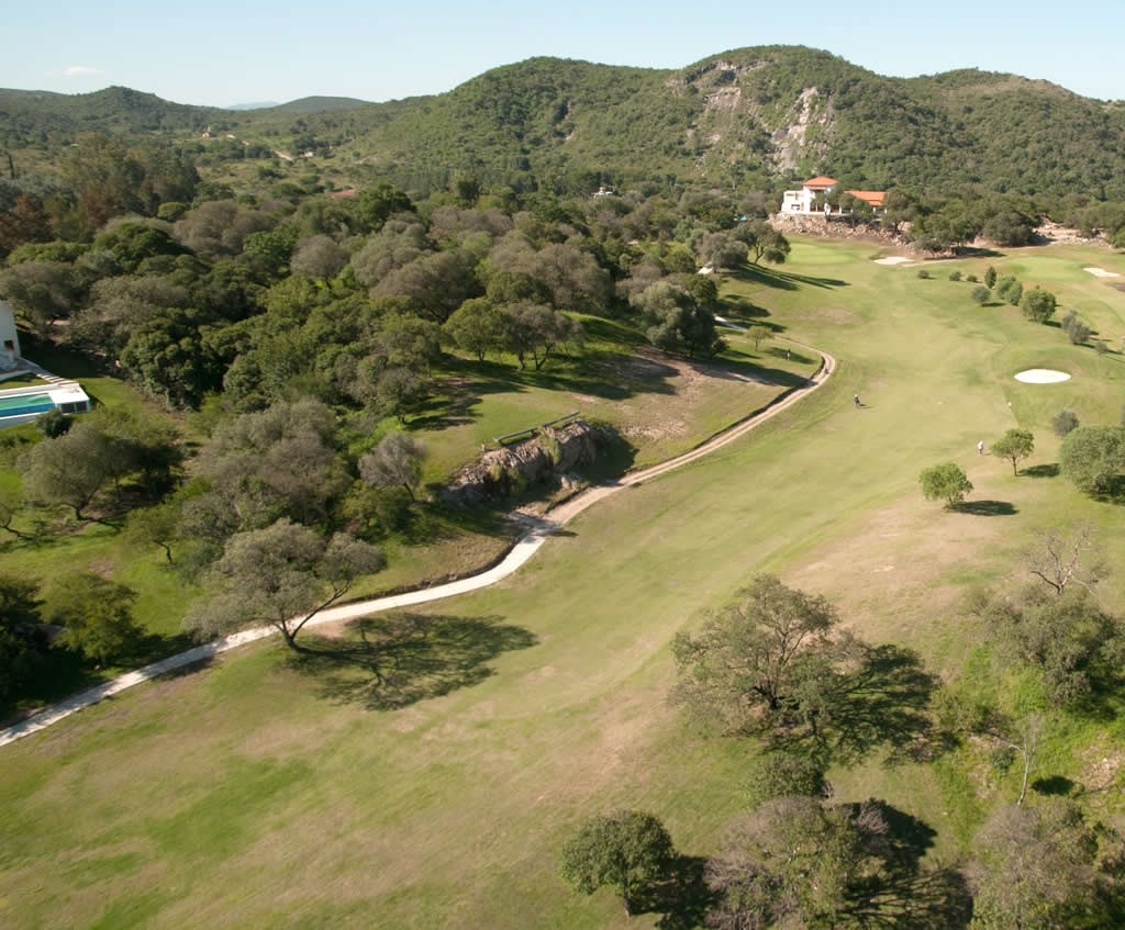 Una vista aérea de un campo de golf rodeado de árboles.