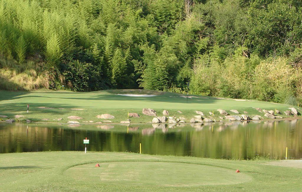 Un campo de golf con un estanque en medio.
