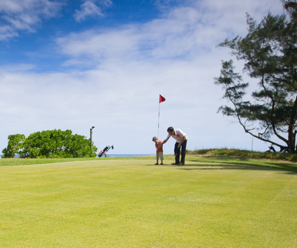 Una familia juega al golf junta en un campo de golf.