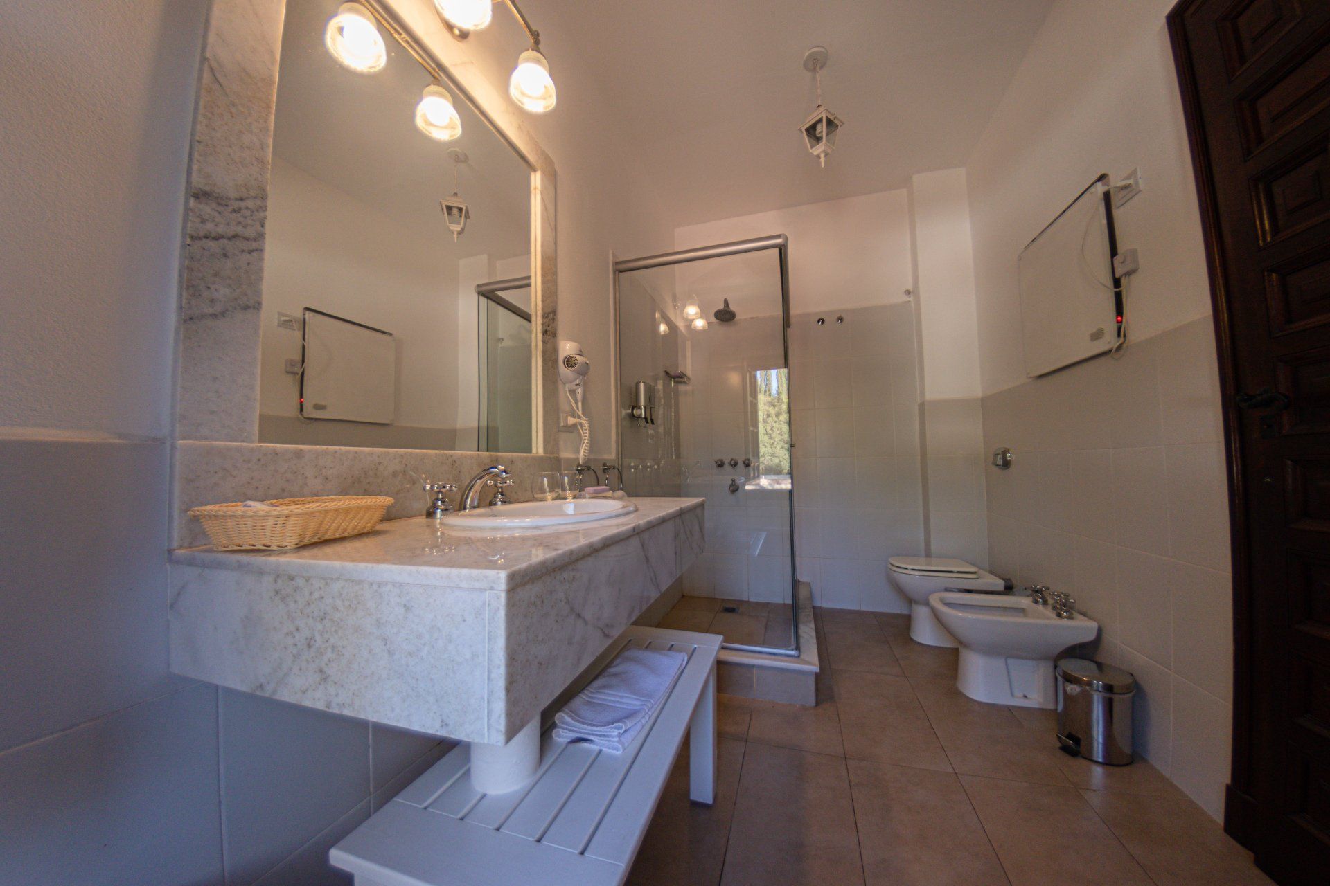 Un baño con dos lavabos, dos sanitarios y una ducha.