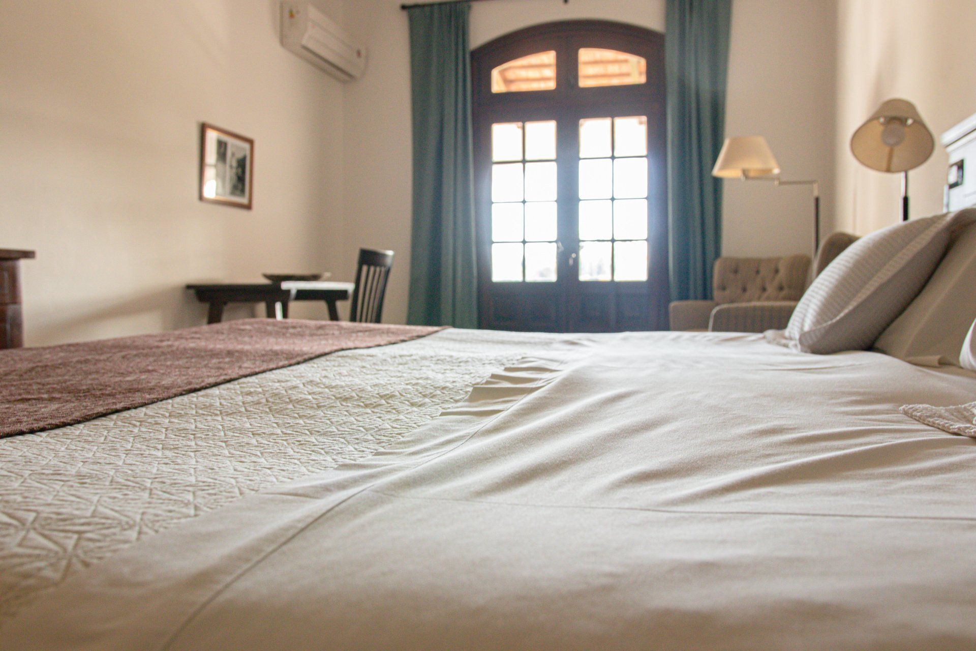 Una cama en una habitación de hotel con mesa y sillas.