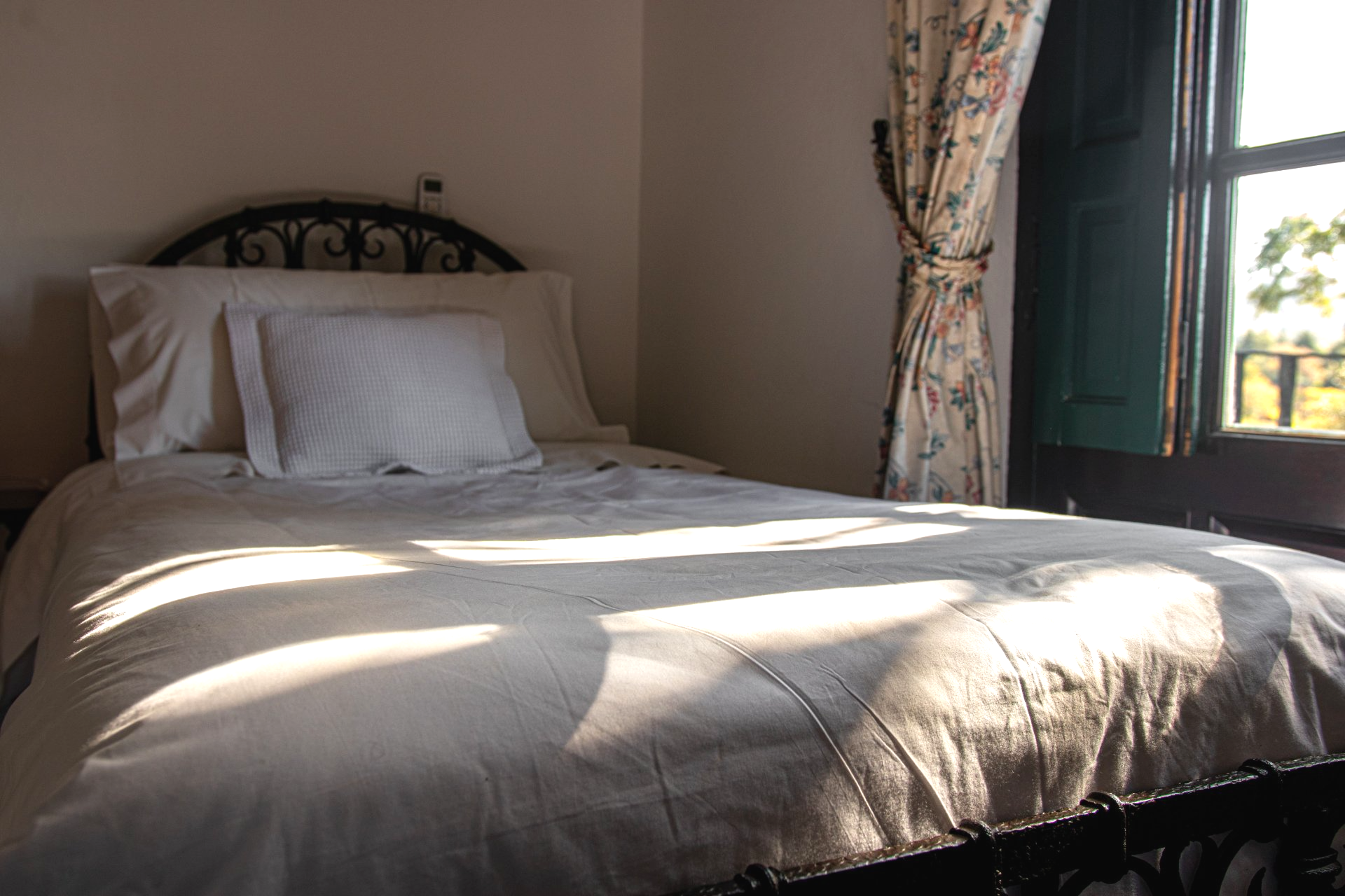 Un dormitorio con una cama y una ventana con contraventanas.