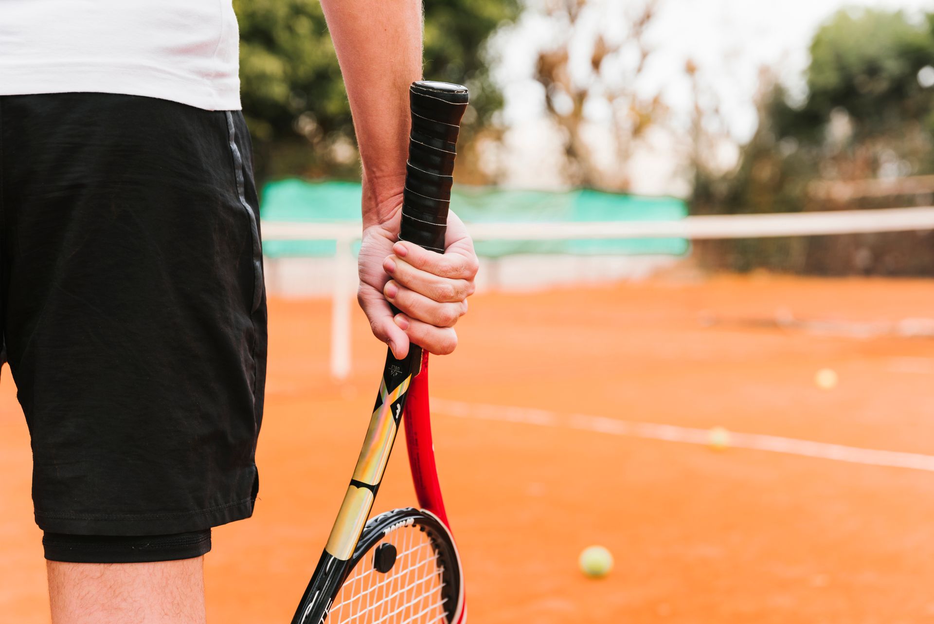Un hombre sostiene una raqueta de tenis en una cancha de tenis.