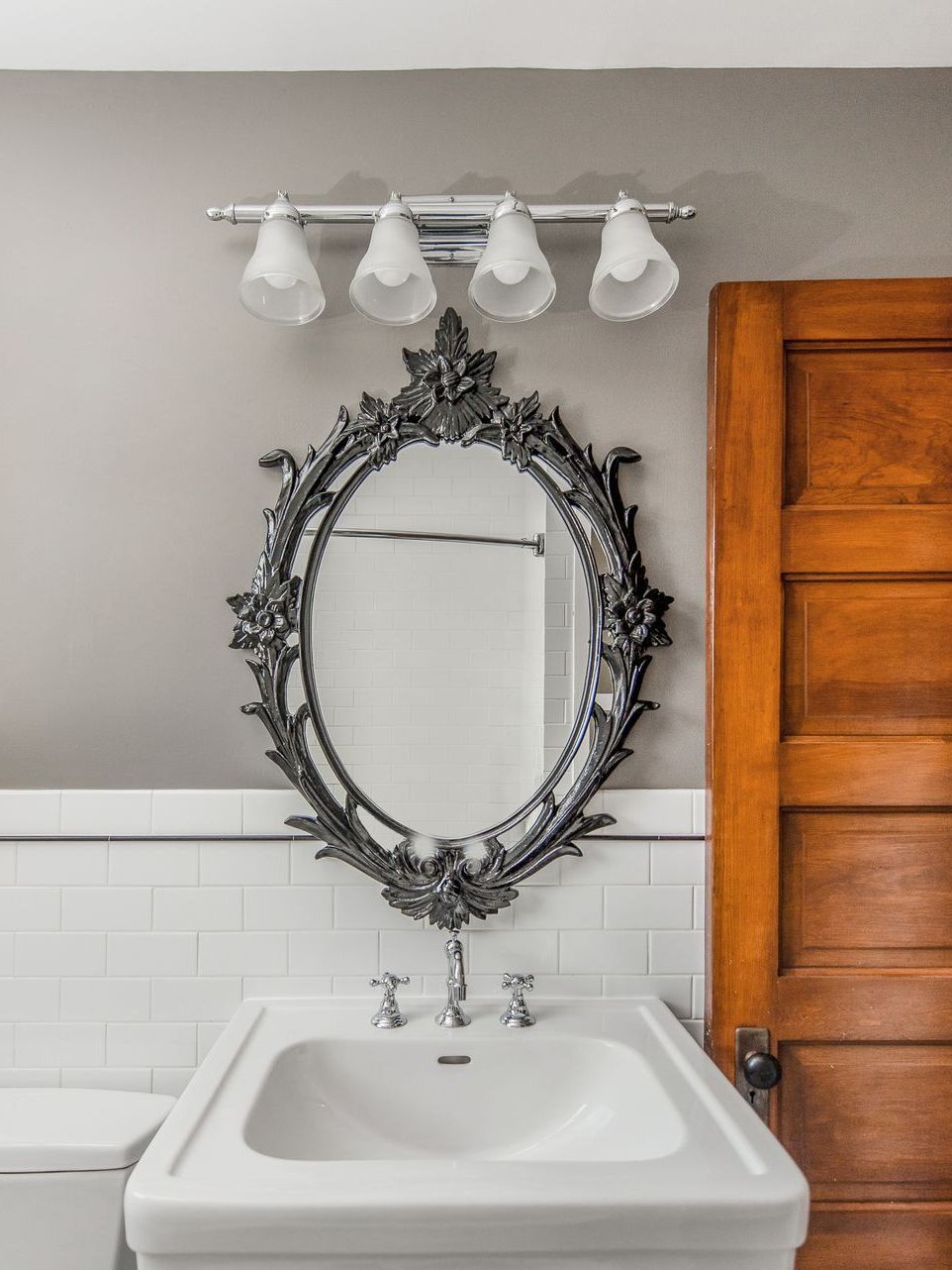 A bathroom with a sink a toilet and a mirror