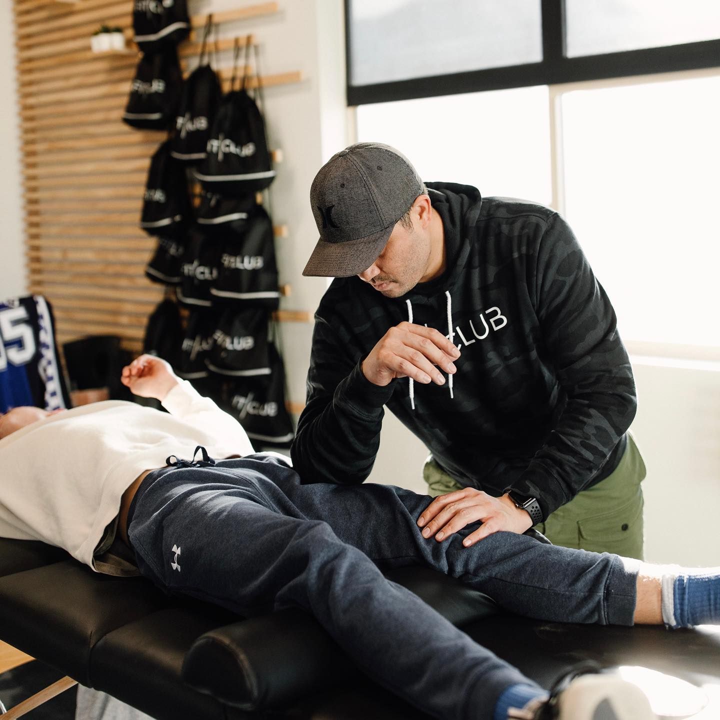 FitClub trainer provides hands-on support during workout for personalized fitness guidance.