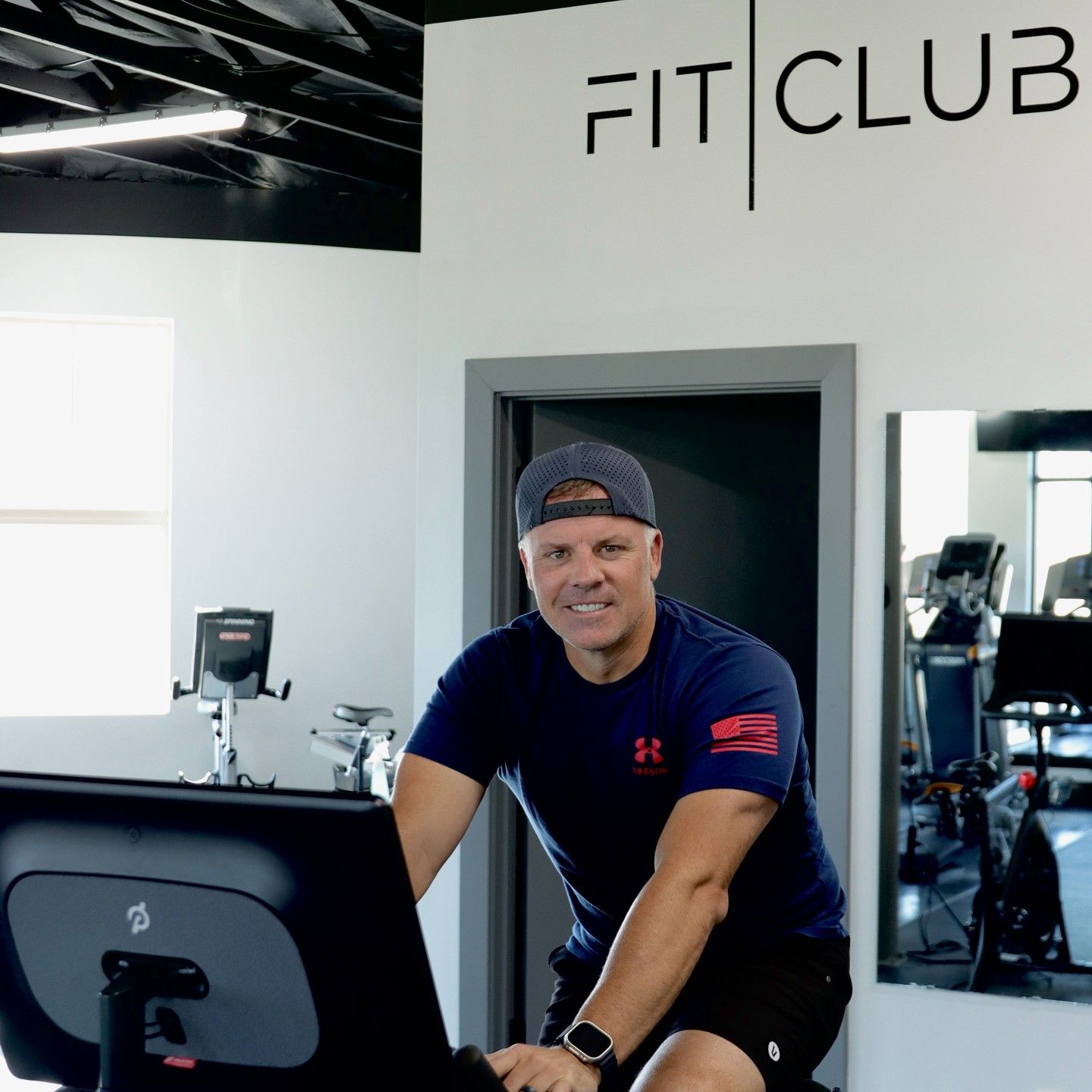 A man using a cardio bike in a gym.