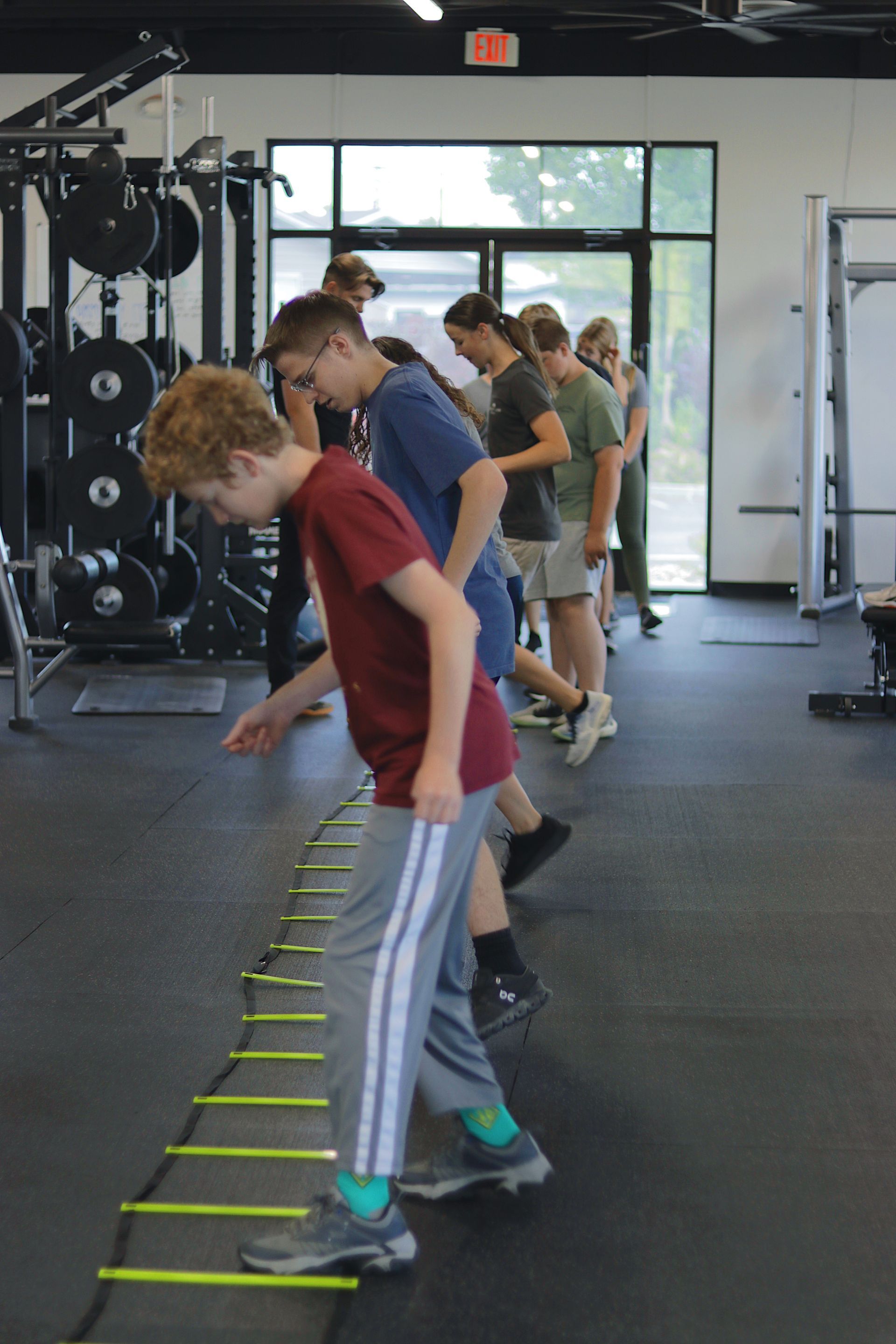 People participating in a group training session at FitClub, guided by a fitness instructor in a gym