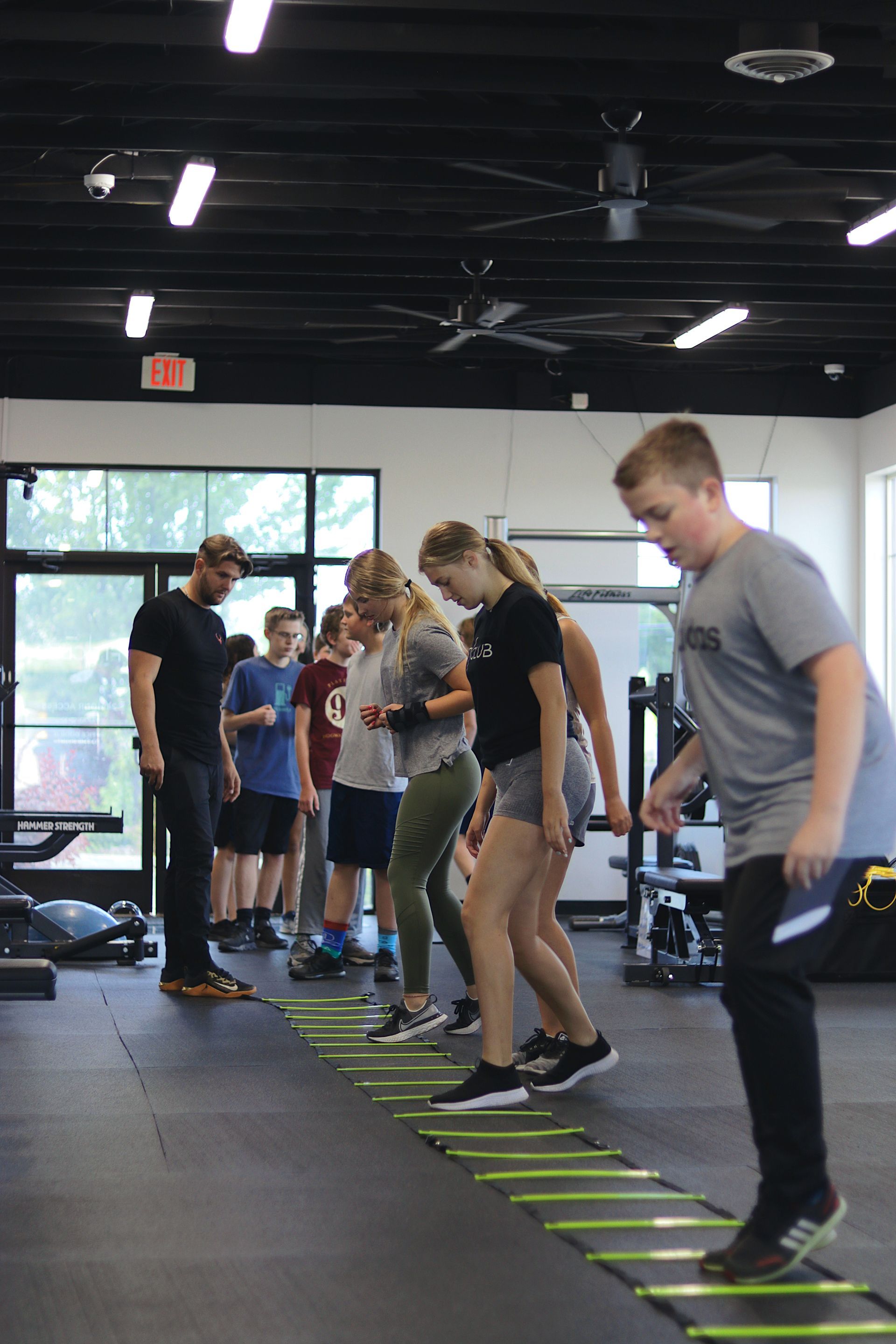 Teen fitness class at FitClub in Salem, Utah, engaging in group training exercises.

