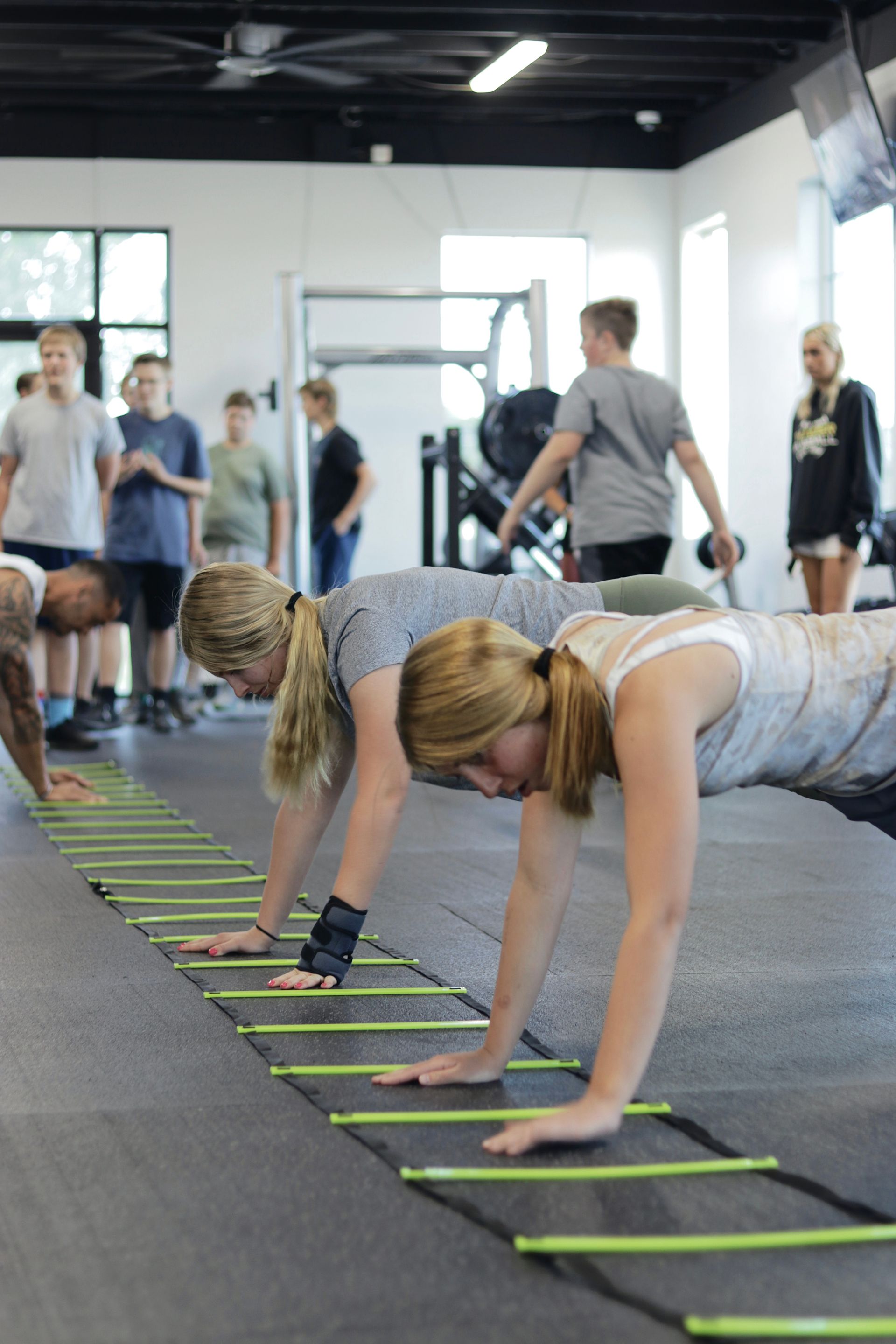 Group training session at FitClub in Salem, Utah, focusing on bodyweight exercises like push-ups.