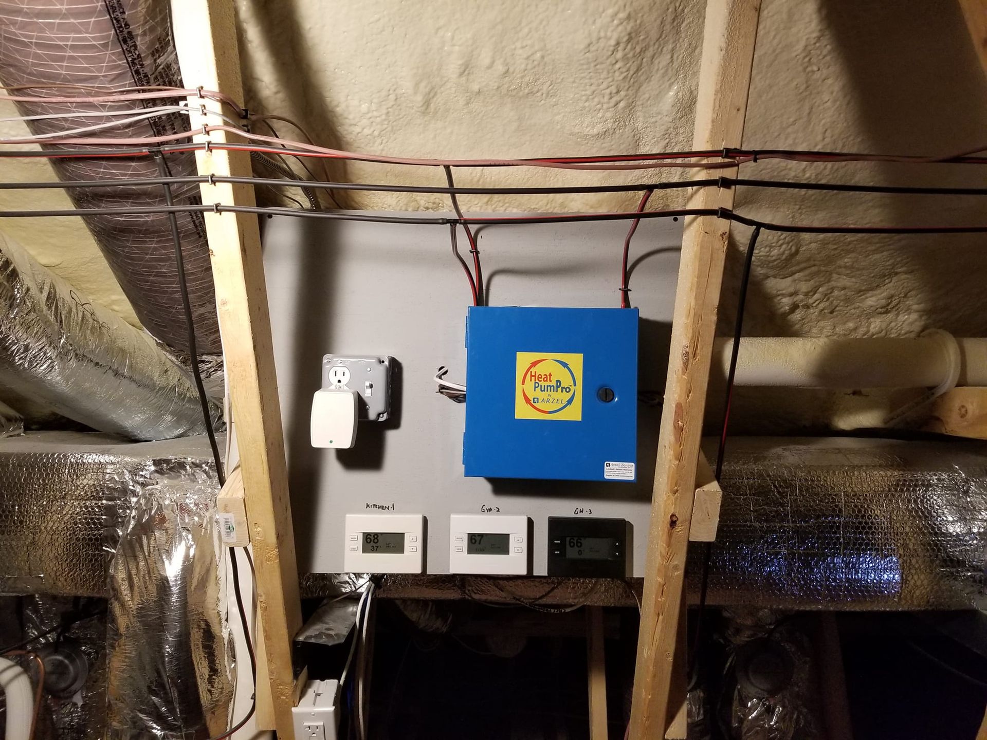 A blue box with a yellow sticker on it is hanging from the ceiling of a room.