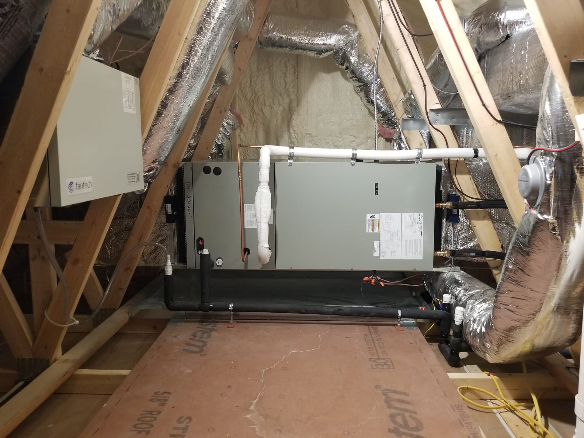 An attic with a heater and pipes in it