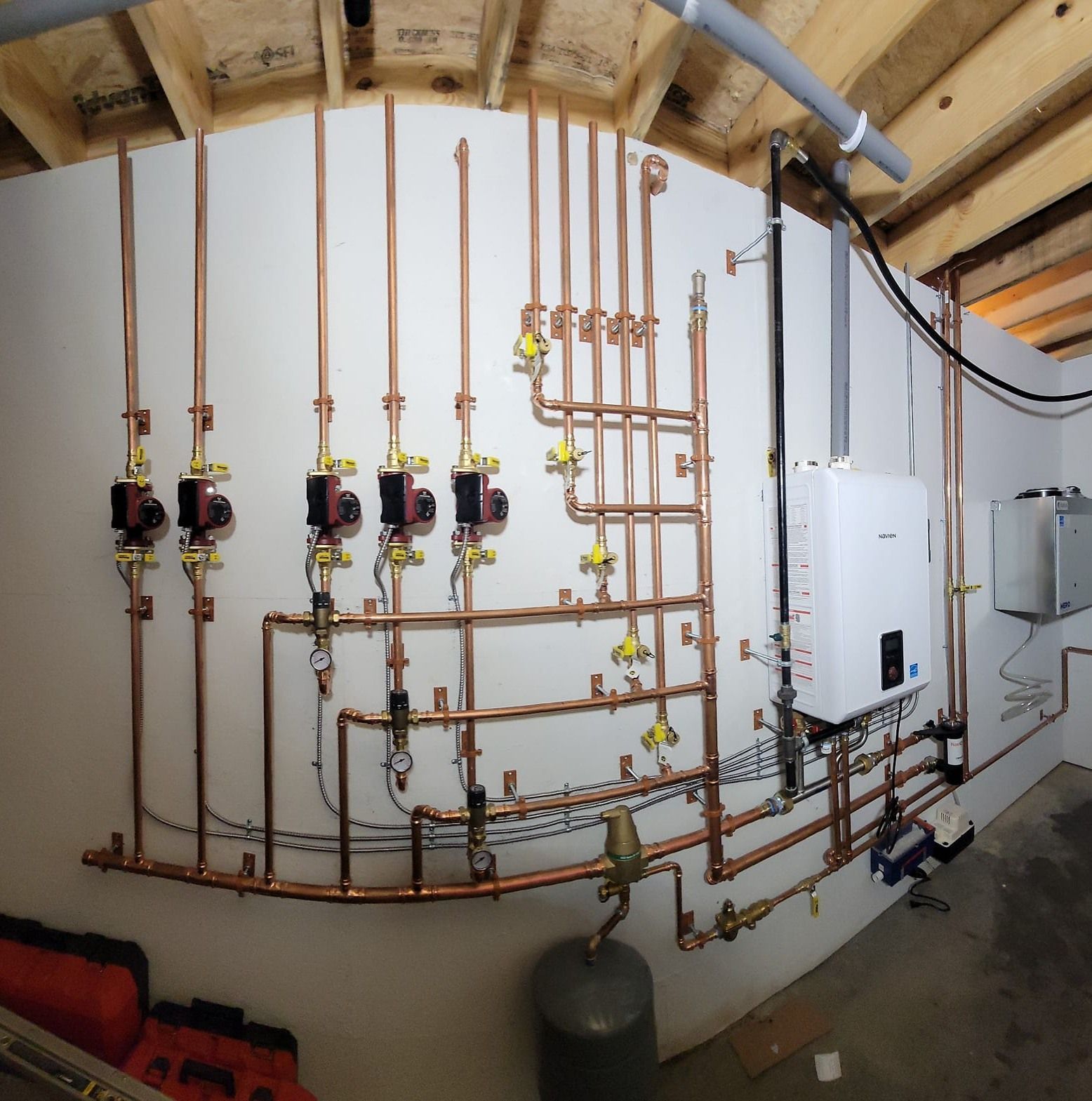 Copper pipes are lined up on a wall in a room
