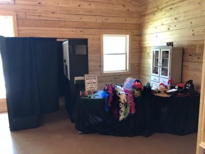 Booth with black drapes and colorful accessories in a wood-paneled room