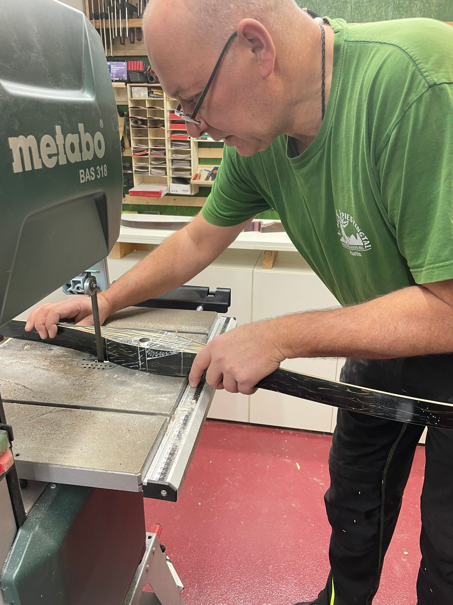 Ein Mann im grünen Hemd arbeitet an einer Metabo-Bandsäge