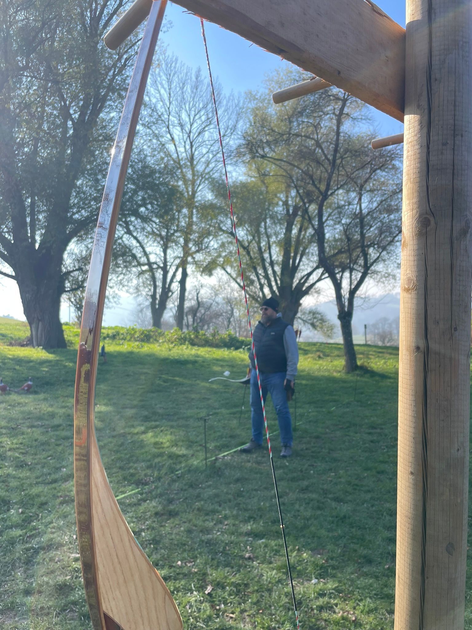 Ein Mann steht auf einer Wiese mit Bäumen im Hintergrund
