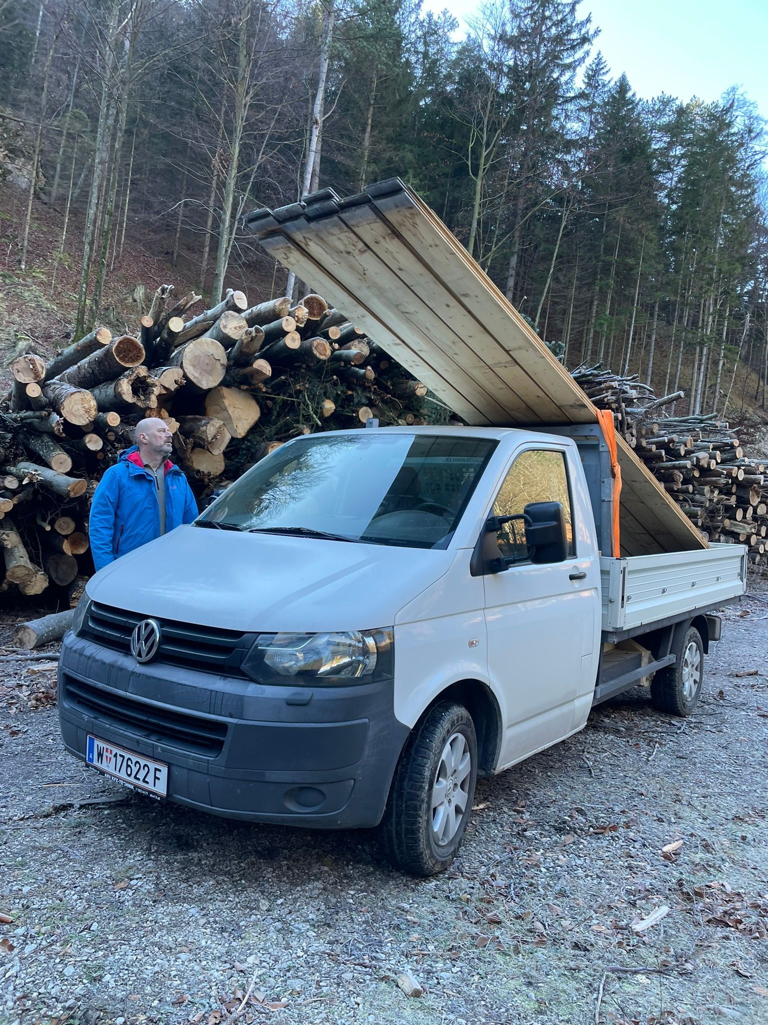 Ein Mann steht neben einem weißen Lastwagen mit Holzdach.