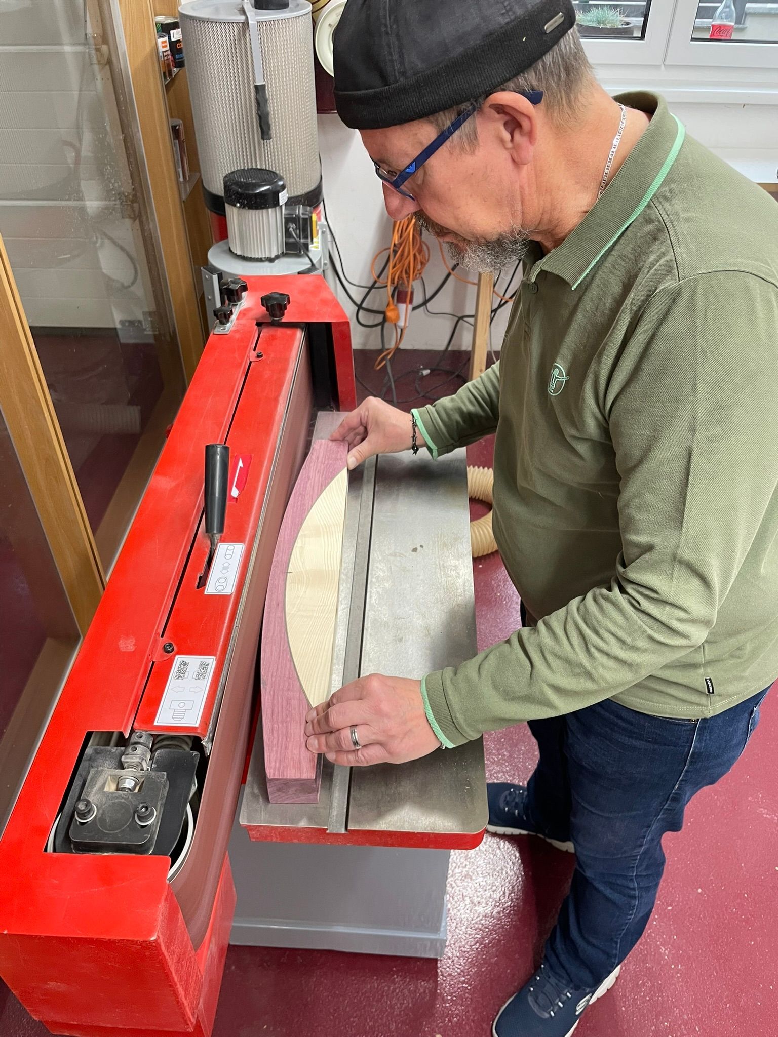 Ein Mann im grünen Hemd arbeitet an einer Maschine